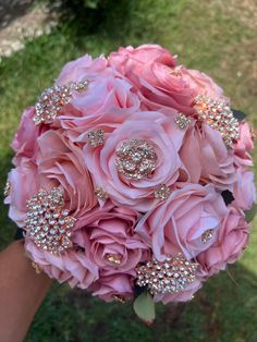 a bride's bouquet with pink roses and crystal brooches