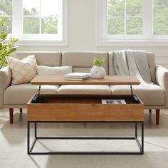 a living room scene with focus on the couch and coffee table in front of the window