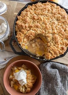 a peach cobbler is served with whipped cream