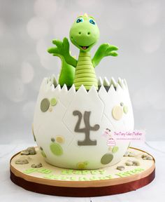 a birthday cake with a dinosaur in an egg shell