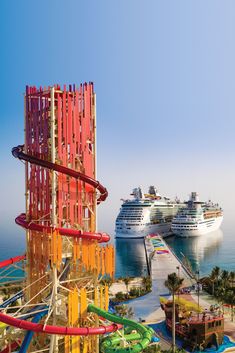 two cruise ships are in the background and an amusement park is in the foreground