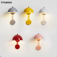 four different colored lamps are hanging on the wall