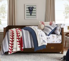 a baseball themed bed in a child's bedroom with striped comforter and pillows