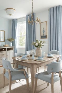 a dining room table and chairs with blue curtains on the windowsills behind them