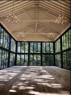 an empty room with large windows and lots of lights hanging from the ceiling in front of it