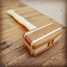 a wooden cutting board with a large knife on it's end, resting on the floor