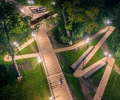 an aerial view of a park at night with stairs lit up and people walking down the path