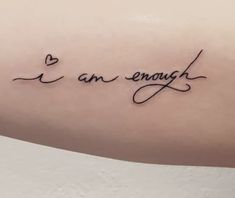 a woman's arm with the words i am enough written in cursive writing