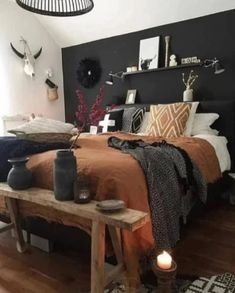 a bed room with a neatly made bed next to a wooden table and two candles