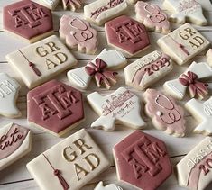 some decorated cookies are laying on a white wooden table with pink and white icing