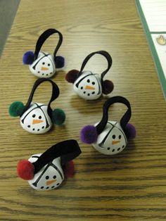 four snowman headphones sitting on top of a wooden table