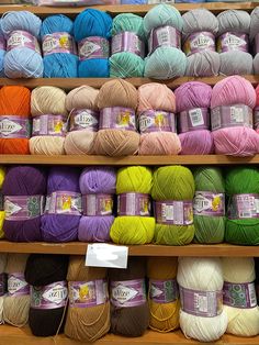 many balls of yarn are displayed on shelves