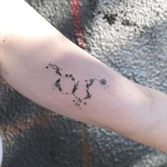 a person's arm with a clock and stars tattoo on the left side of their arm