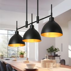 three lights hanging over a dining room table