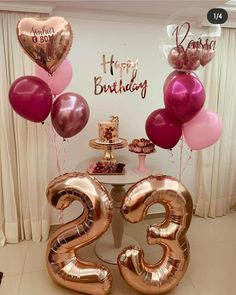 a table topped with balloons and cake next to a number twenty five birthday cake on top of a table