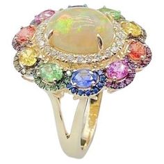 The Following Item we are offering is a Rare Important Radiant 18KT Gold Large Fancy Fiery White Opal Diamond Multi Sapphire Ring. Ring is comprised of A LARGE Gorgeous Fancy Fiery White Rainbow Opal surrounded by Beautiful Glittering Diamonds and an Exquisite Array of Multi Colored Sapphires. T.C.W APPROX 6 CTS!!! Comes with New with Tags from a Private Manufacturer that sells to Important 5 Star Hotel and Fine Jewelry Stores. Original Retail Price: $9,509.00. Comes with a Certified Report from Blue Sapphire Diamond Ring, Single Stone Ring, Rainbow Sapphires, Vintage Cocktail Ring, Rainbow Opal, Multi Sapphire, Purple Jewelry, Blue Sapphire Diamond, Sapphire Diamond Ring