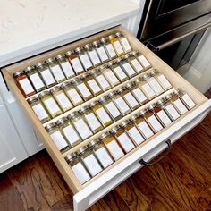 a drawer full of honey bottles with labels on them sitting in front of an oven