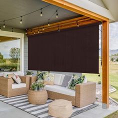 an outdoor living area with wicker furniture and lights on the ceiling, covered in brown shades