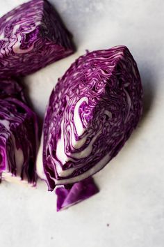 three pieces of red cabbage on a white surface