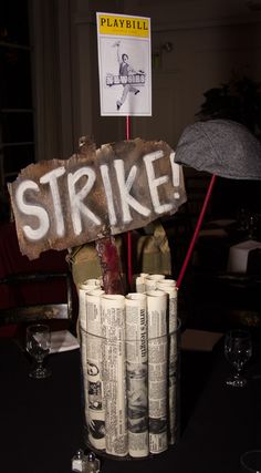 a table topped with stacks of money and a sign that says strike next to an umbrella