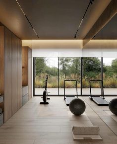 there are many exercise balls in the room and on the treadmills near the windows