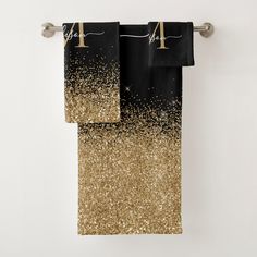 two black and gold towels hanging on a towel rack