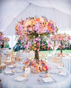 a table is set up with flowers and place settings for an elegant wedding reception at the park