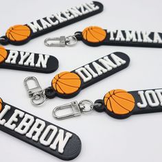 four basketball keychains with name tags and clippings attached to each one