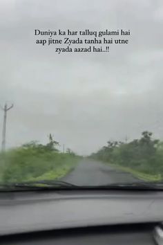 a car driving down a rural road in the rain