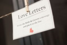 a sign hanging from a rope that says love letters