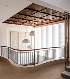 an empty room with two lamps on the ceiling and a staircase leading up to it