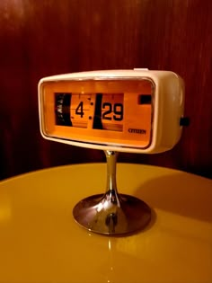 an alarm clock sitting on top of a yellow table