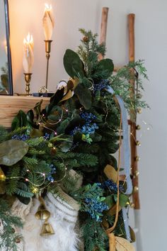 a christmas wreath with bells and greenery on the mantle next to a fireplace mantel