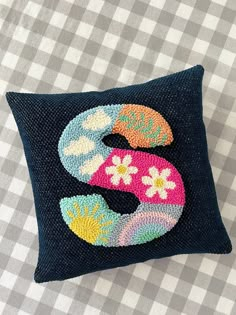 a decorative pillow with the letter s on it