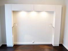 an empty room with white walls and wooden flooring is shown in this image, there are no doors on the wall