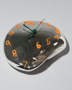 a clock with numbers on it sitting on a white counter top in the shape of a fish