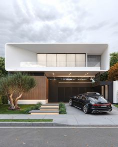 a black car parked in front of a modern house