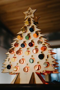 a wooden christmas tree with lots of buttons on it