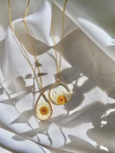 two necklaces that have flowers on them