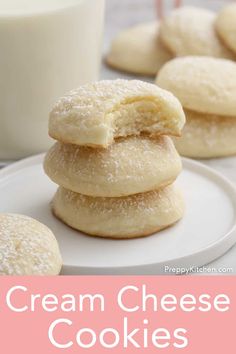 cream cheese cookies stacked on top of each other with a glass of milk in the background