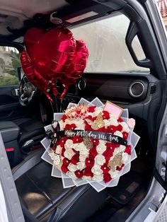 a heart shaped balloon sitting in the back of a car with valentine's day decorations