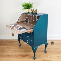 a blue desk with an open drawer on top and a potted plant in the middle