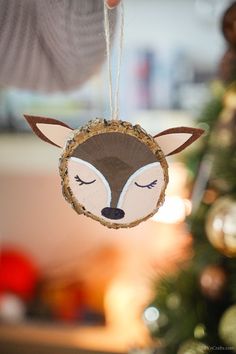 a handmade ornament with a fox face hanging from it's side