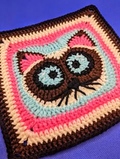 a crocheted square with an image of a cat's face on it