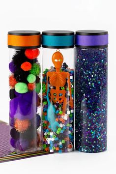 two bottles filled with different types of beads and sprinkles next to each other