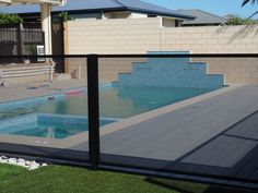 a fenced in swimming pool next to a house