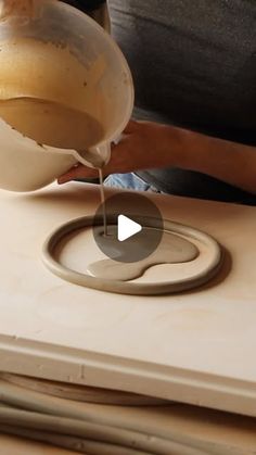 a person pouring something into a bowl on top of a table