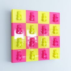 a pink and yellow wall mounted with gummy bears on it's back side