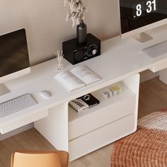 a computer desk with two monitors and a book on it, next to a chair