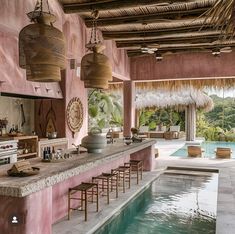 an outdoor kitchen and pool area with wicker hanging from the ceiling